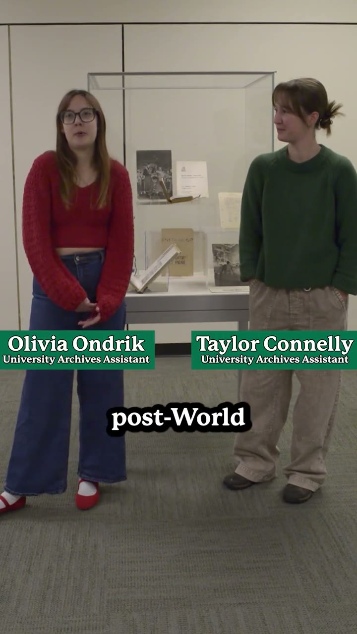 Two University Archives assistants standing beside a display case of archival materials, from an Ohio University Archives social clip